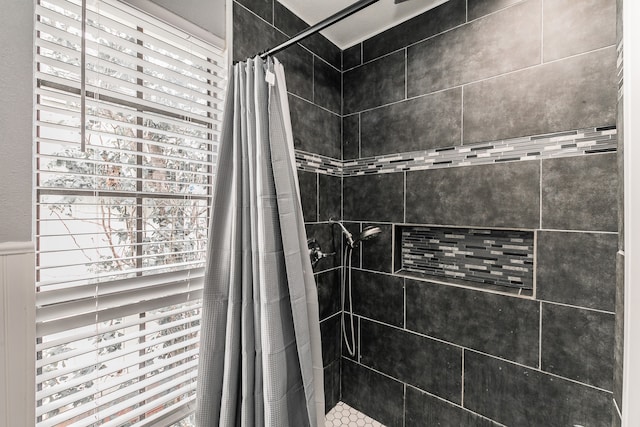 bathroom with a shower with shower curtain and a healthy amount of sunlight