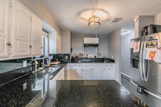 205 Benwynd Dr, Mesquite, TX 75149 - kitchen featuring appliances with stainless steel finishes, white cabinets, a textured ceiling, under cabinet range hood, and dark stone counters