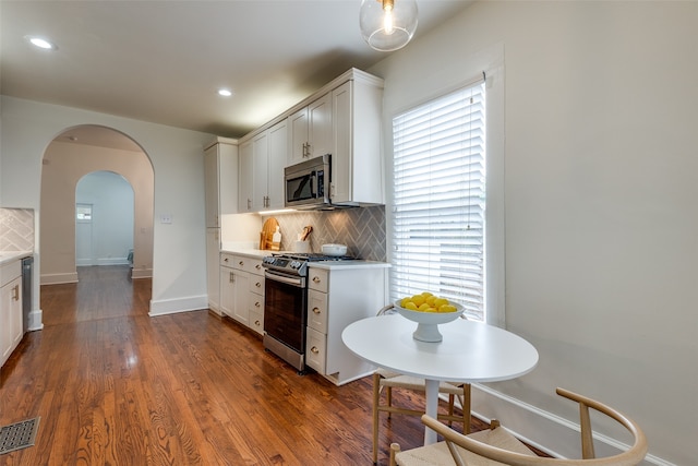 kitchen featuring white cabinets, stainless steel appliances, plenty of natural light, and dark hardwood / wood-style floors