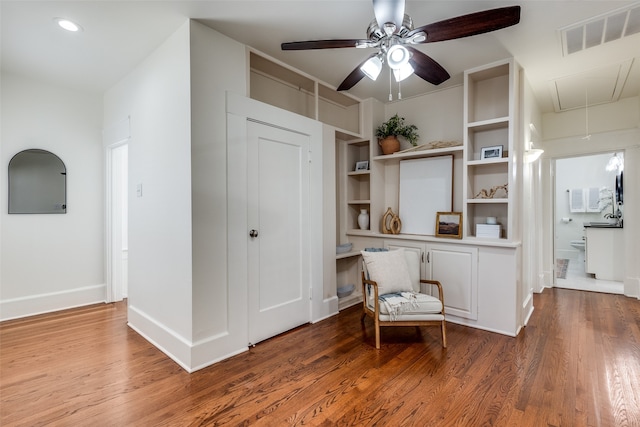 unfurnished room with ceiling fan, built in features, and hardwood / wood-style flooring