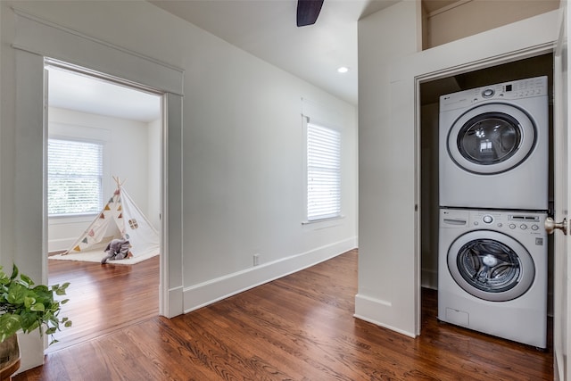 clothes washing area with stacked washer / dryer, dark hardwood / wood-style floors, and ceiling fan