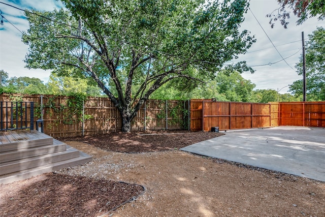 view of yard featuring a wooden deck and a patio area