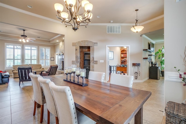 dining area featuring ceiling fan with notable chandelier, light tile patterned flooring, and ornamental molding