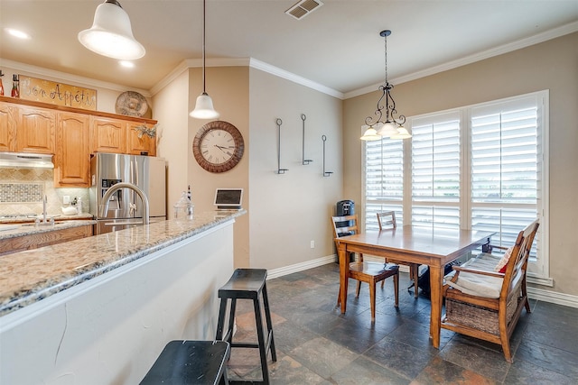 interior space featuring hanging light fixtures, stainless steel fridge with ice dispenser, light stone counters, and tasteful backsplash