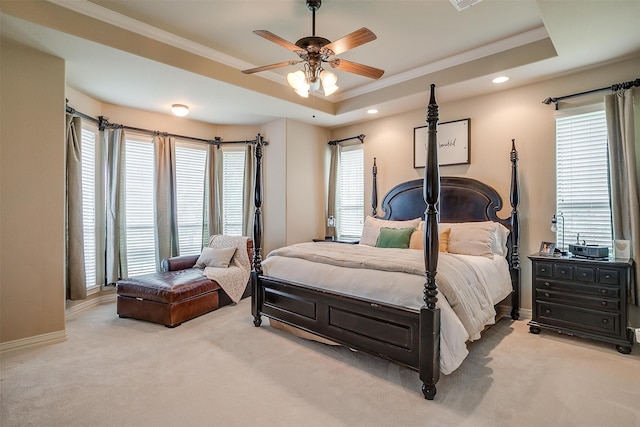 bedroom featuring light carpet, a tray ceiling, ceiling fan, and crown molding