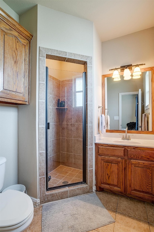 bathroom with vanity, toilet, an enclosed shower, and tile patterned floors