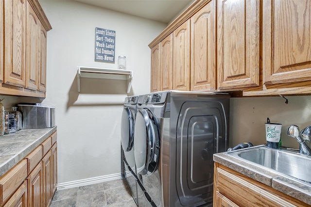 laundry area featuring sink, independent washer and dryer, and cabinets