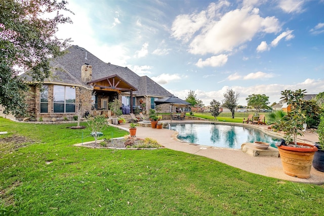 view of pool featuring a lawn and a patio