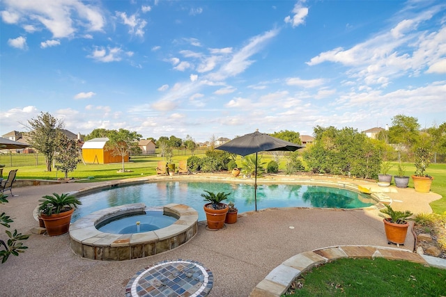 view of pool with a storage shed, an in ground hot tub, a patio area, and a lawn