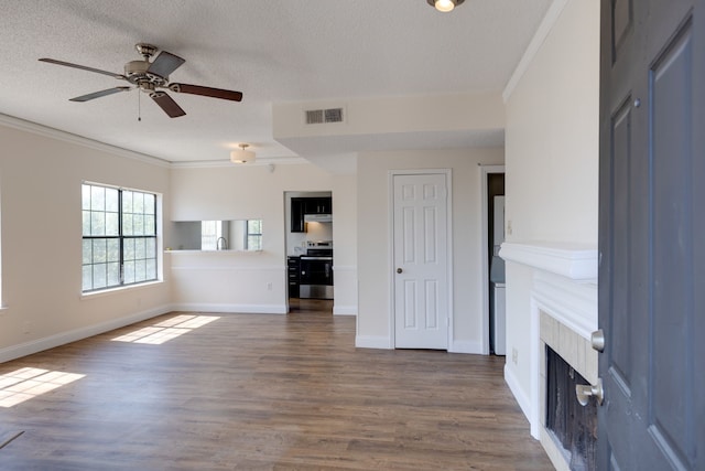 unfurnished living room featuring ceiling fan, ornamental molding, a textured ceiling, and hardwood / wood-style floors