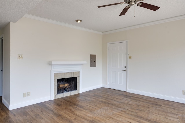 unfurnished living room featuring ceiling fan, a fireplace, ornamental molding, hardwood / wood-style flooring, and a textured ceiling