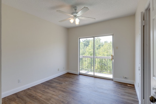 empty room featuring dark wood-type flooring, a textured ceiling, and ceiling fan