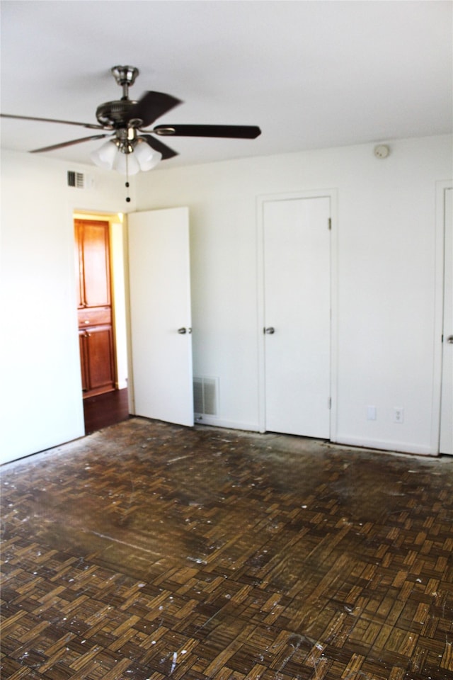 empty room with ceiling fan and dark hardwood / wood-style floors