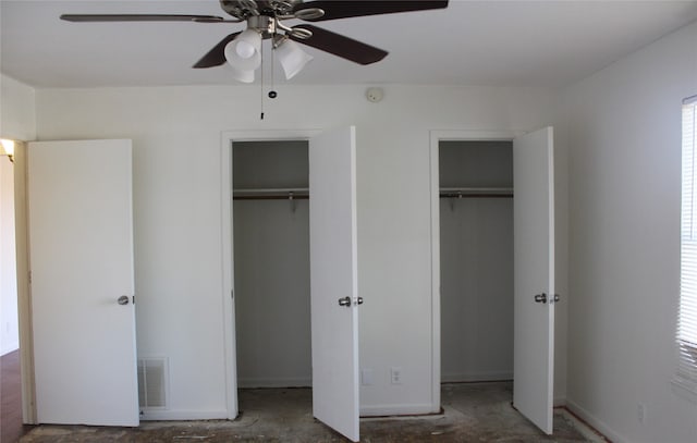 unfurnished bedroom with ceiling fan and multiple closets