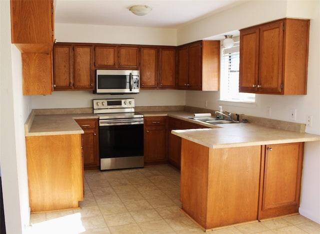 kitchen with kitchen peninsula, appliances with stainless steel finishes, and sink