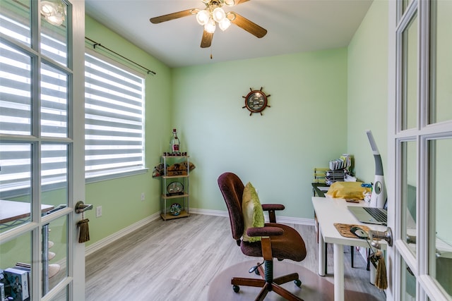 office with light wood-type flooring, ceiling fan, and french doors