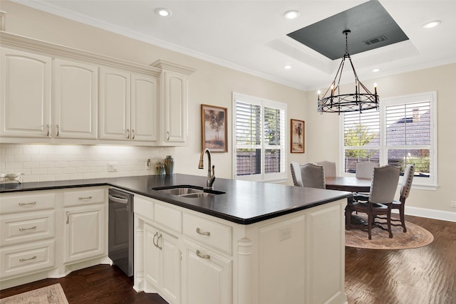 kitchen featuring backsplash, a raised ceiling, pendant lighting, sink, and a notable chandelier