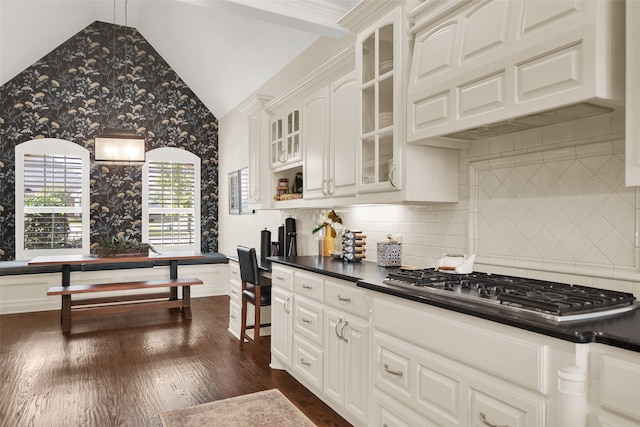 kitchen with decorative backsplash, white cabinetry, lofted ceiling, premium range hood, and dark hardwood / wood-style floors