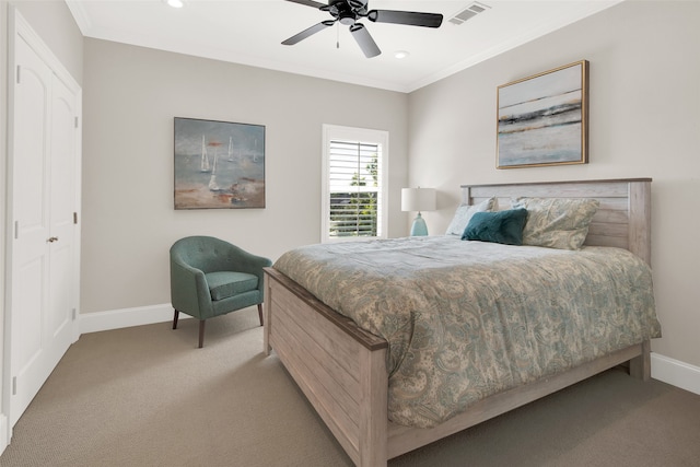 bedroom featuring a closet, ceiling fan, light colored carpet, and crown molding