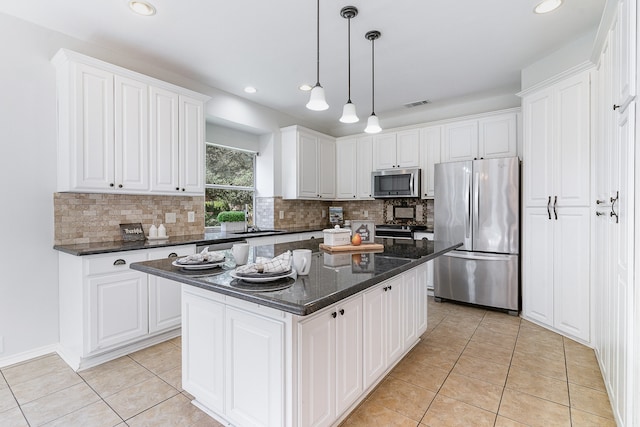 kitchen featuring a center island, white cabinets, hanging light fixtures, light tile patterned floors, and stainless steel appliances