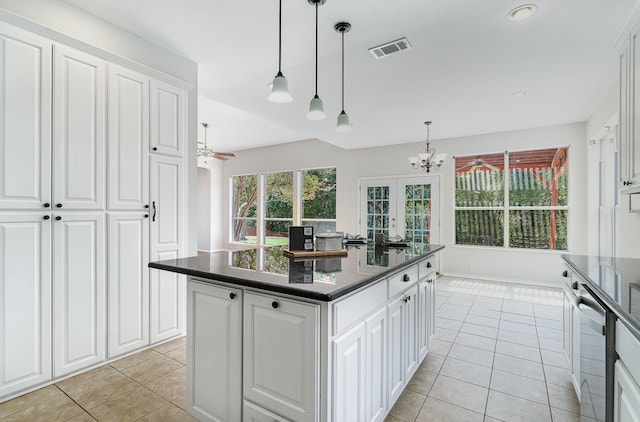 kitchen with white cabinets, a center island, and decorative light fixtures