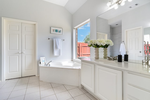 bathroom with tile patterned floors, a healthy amount of sunlight, and lofted ceiling