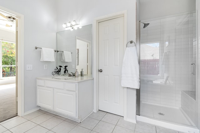 bathroom featuring tile patterned floors, a shower with door, and vanity