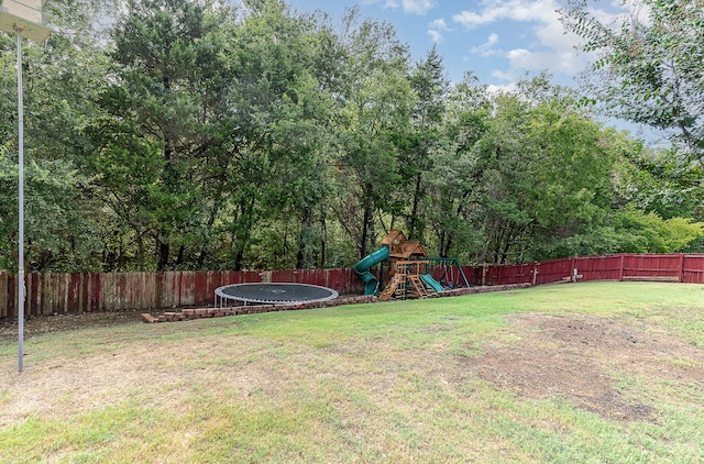 view of yard with a playground and a trampoline