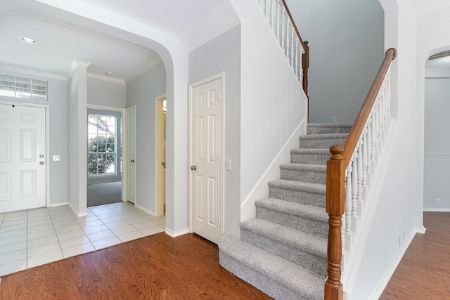 foyer entrance with light hardwood / wood-style floors and crown molding