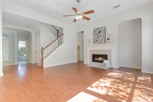 unfurnished living room featuring ceiling fan, light hardwood / wood-style floors, and a fireplace