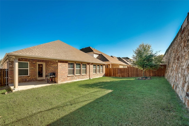 rear view of property with a yard and a patio