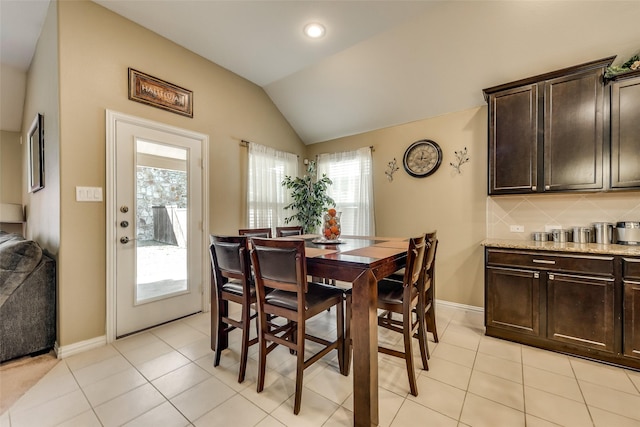 dining area featuring light tile patterned floors and lofted ceiling