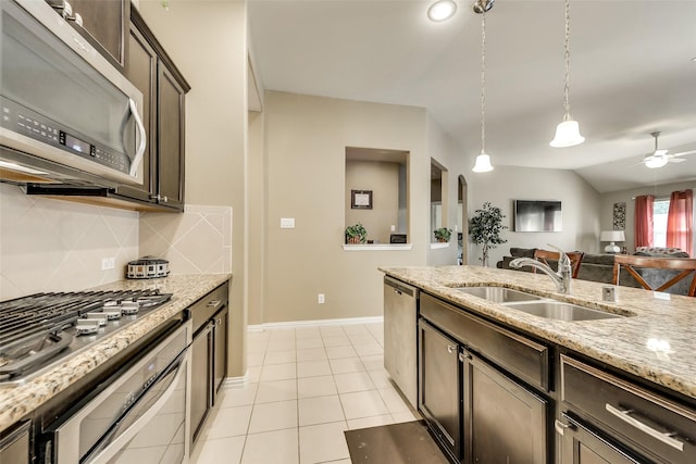 kitchen featuring pendant lighting, backsplash, sink, dark brown cabinetry, and stainless steel appliances