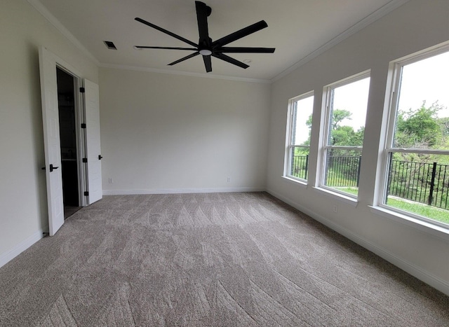 carpeted empty room with ceiling fan and crown molding