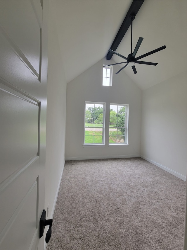 empty room featuring ceiling fan, vaulted ceiling with beams, and light colored carpet