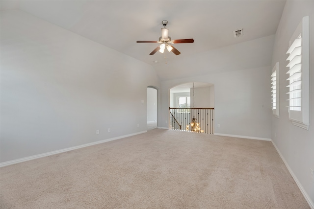 unfurnished room with carpet floors, lofted ceiling, ceiling fan, and plenty of natural light