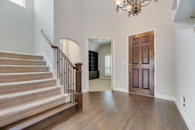 entrance foyer with an inviting chandelier, dark wood-type flooring, and a high ceiling