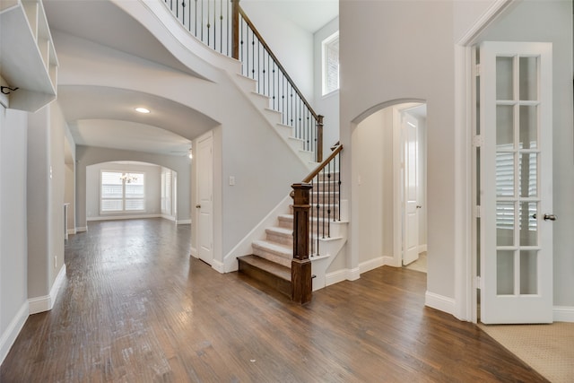 entrance foyer featuring a towering ceiling and dark hardwood / wood-style floors