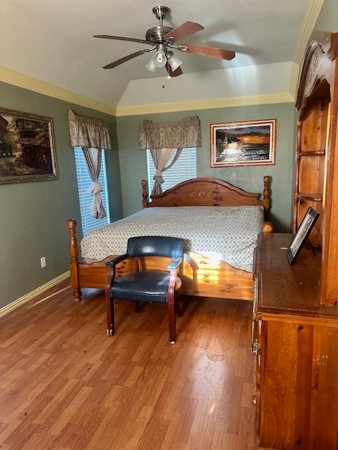 bedroom with lofted ceiling, hardwood / wood-style flooring, and crown molding