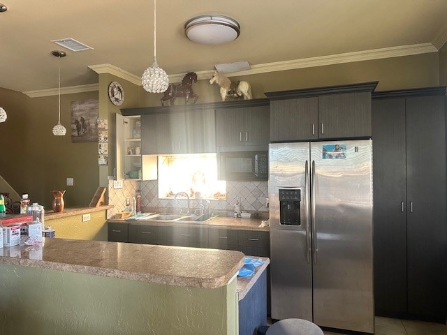 kitchen with ornamental molding, sink, kitchen peninsula, decorative light fixtures, and stainless steel fridge with ice dispenser