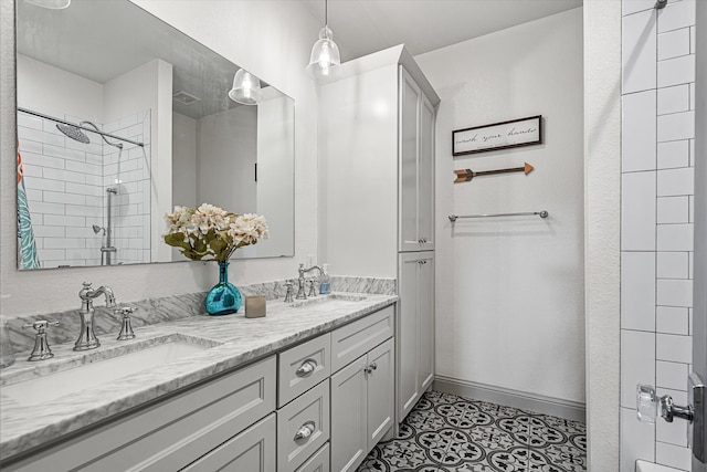 bathroom featuring tiled shower, vanity, and tile patterned floors