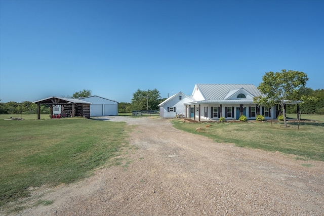 country-style home featuring a front lawn, covered porch, a garage, and an outdoor structure