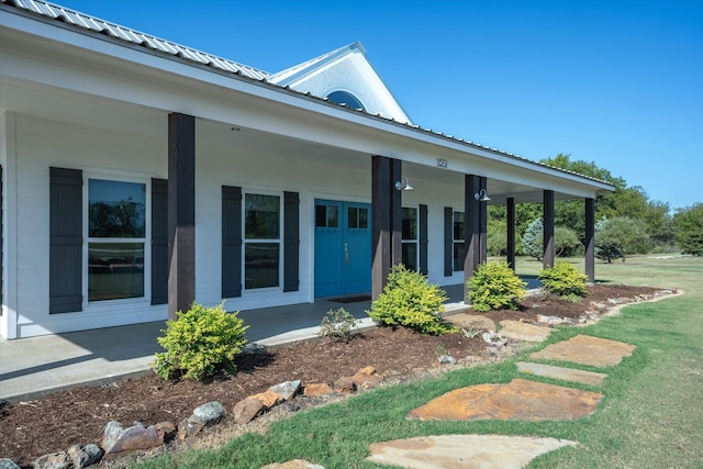 doorway to property featuring a yard and covered porch