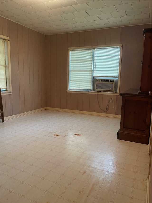 empty room featuring cooling unit and wood walls