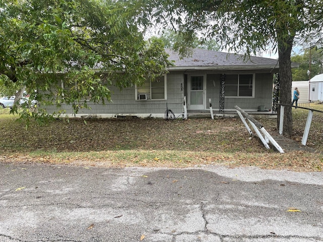 view of front of home with a storage shed and a porch