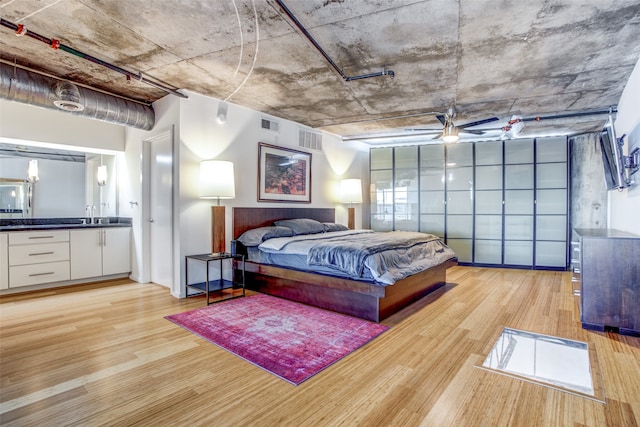 bedroom featuring light wood-type flooring and sink