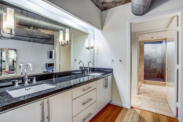 bathroom featuring a tile shower, vanity, and hardwood / wood-style flooring