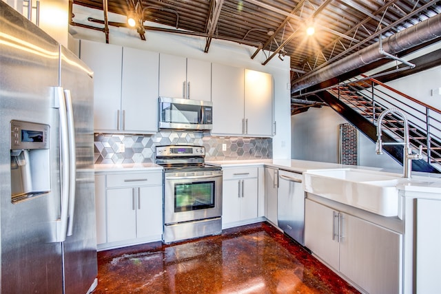 kitchen with decorative backsplash, stainless steel appliances, white cabinets, and sink