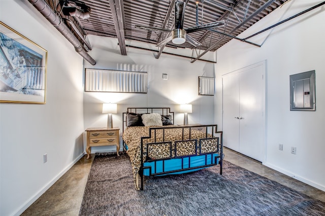 bedroom featuring electric panel, a towering ceiling, and concrete floors