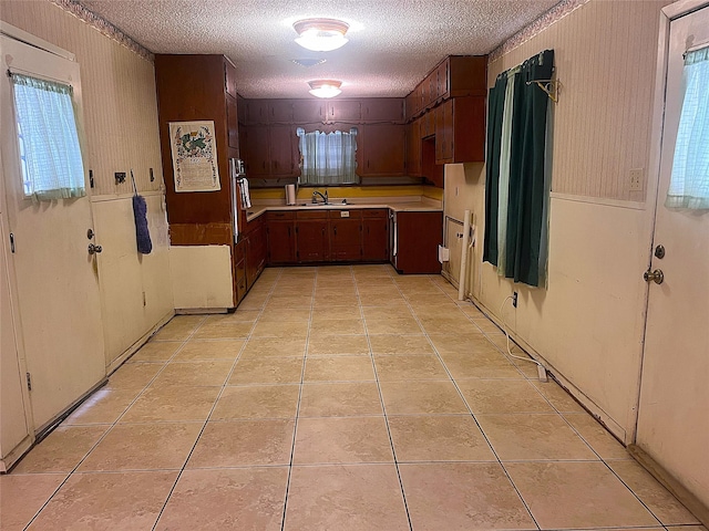 3504 Westfield Ave, Fort Worth, TX 76133 - kitchen featuring a textured ceiling, a sink, light countertops, and light tile patterned floors